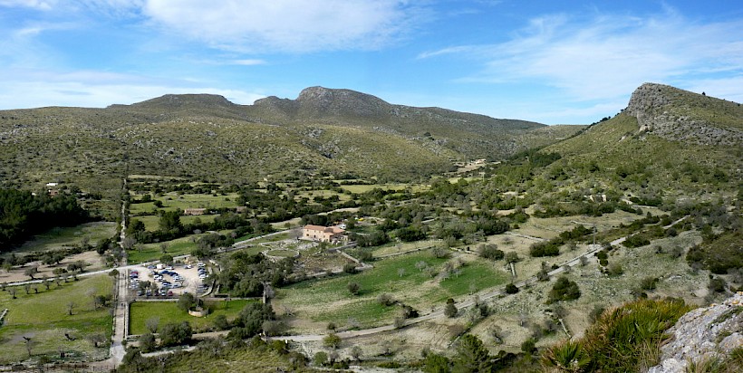 Vall i cases de s'Alqueria Vella de Baix; al fons, el puig de sa Creu i sa Talaia Freda; a la dreta, es puig des Corb
